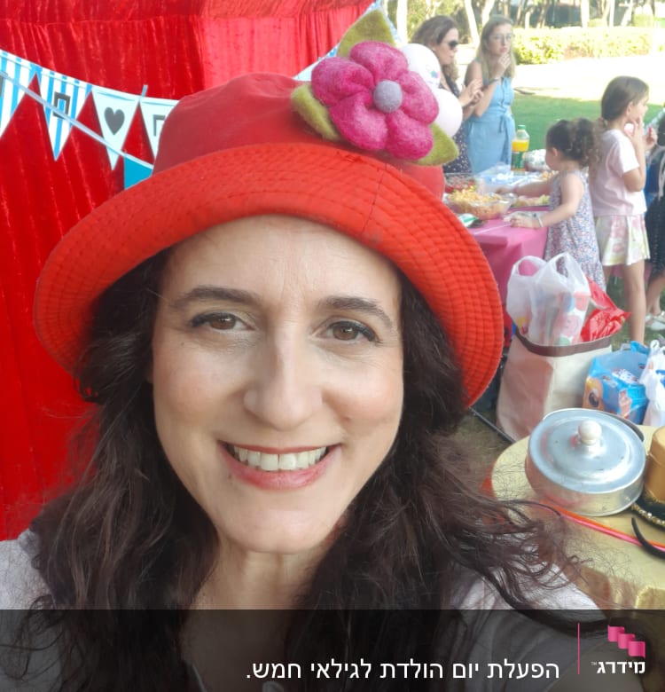 אישה עם כובע אדום, שולחן עם חטיפים, ילדים משחקים